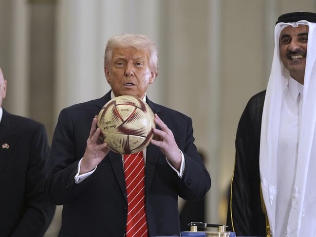 US President Donald Trump handles a FIFA soccer ball as Qatar’s Emir Sheikh Tamim bin Hamad Al Thani looks on at the Lusail Palace. Picture: AP