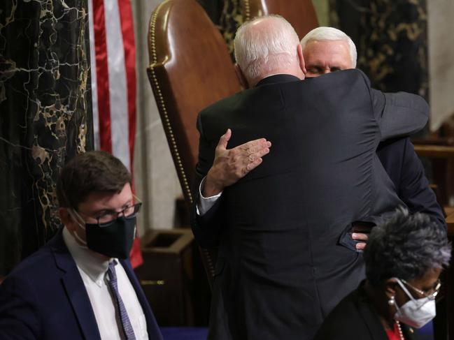 Vice President Mike Pence is hugged at the conclusion of the count of electoral votes in the House Chamber. Picture: Getty Images.