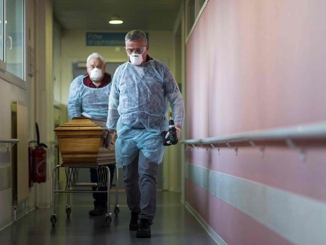 Employees of the Lantz funeral company, wearing face masks as protective measures, pull the coffin of a victim of the COVID-19 at an hospital in Mulhouse, eastern France. Picture: AFP