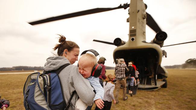 The last of the remaining evacuees are airlifted out of Mallacoota Airport by ADF chinook helicopters on Sunday. Picture: David Caird