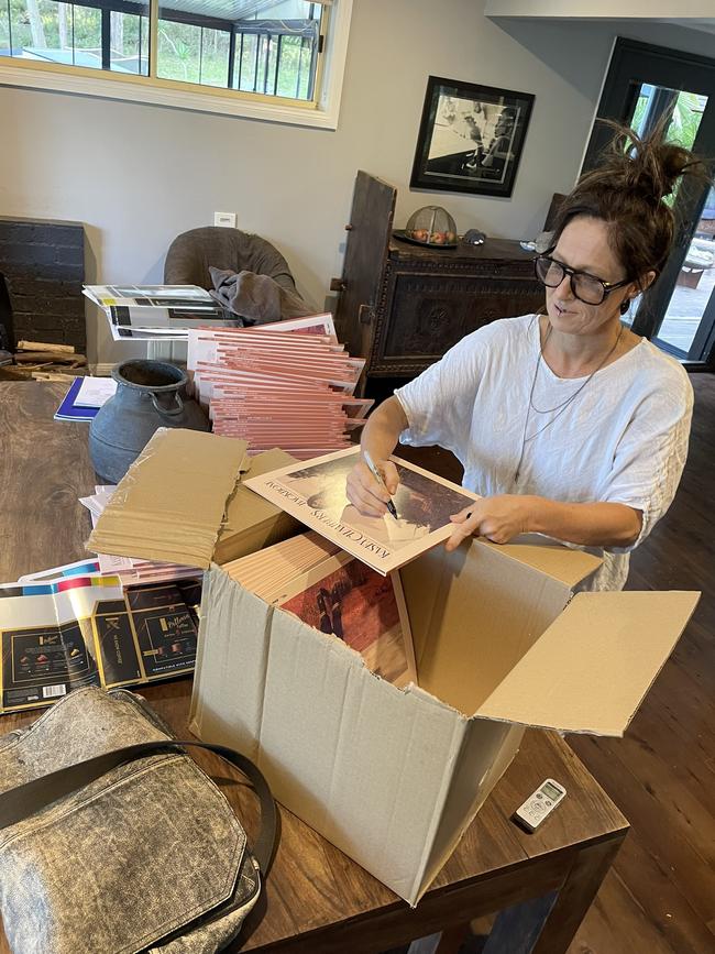 Kasey Chambers signing vinyl sleeve covers for her album 'Backbone' at her home. Picture: Andrew McMillen