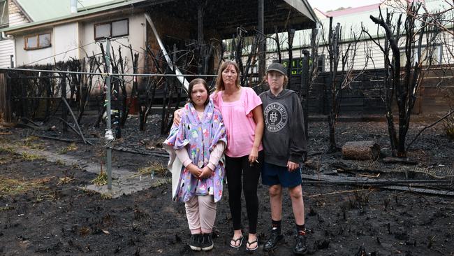 A bushfire in the Montrose area has destroyed one house. The neighbours pictured next door had their back yard burnt. Pic of Terry Moyle and her kids Jack 12, and Angel 11. Neighbours house behind. Sunday, March 16, 2025. Picture: David Crosling