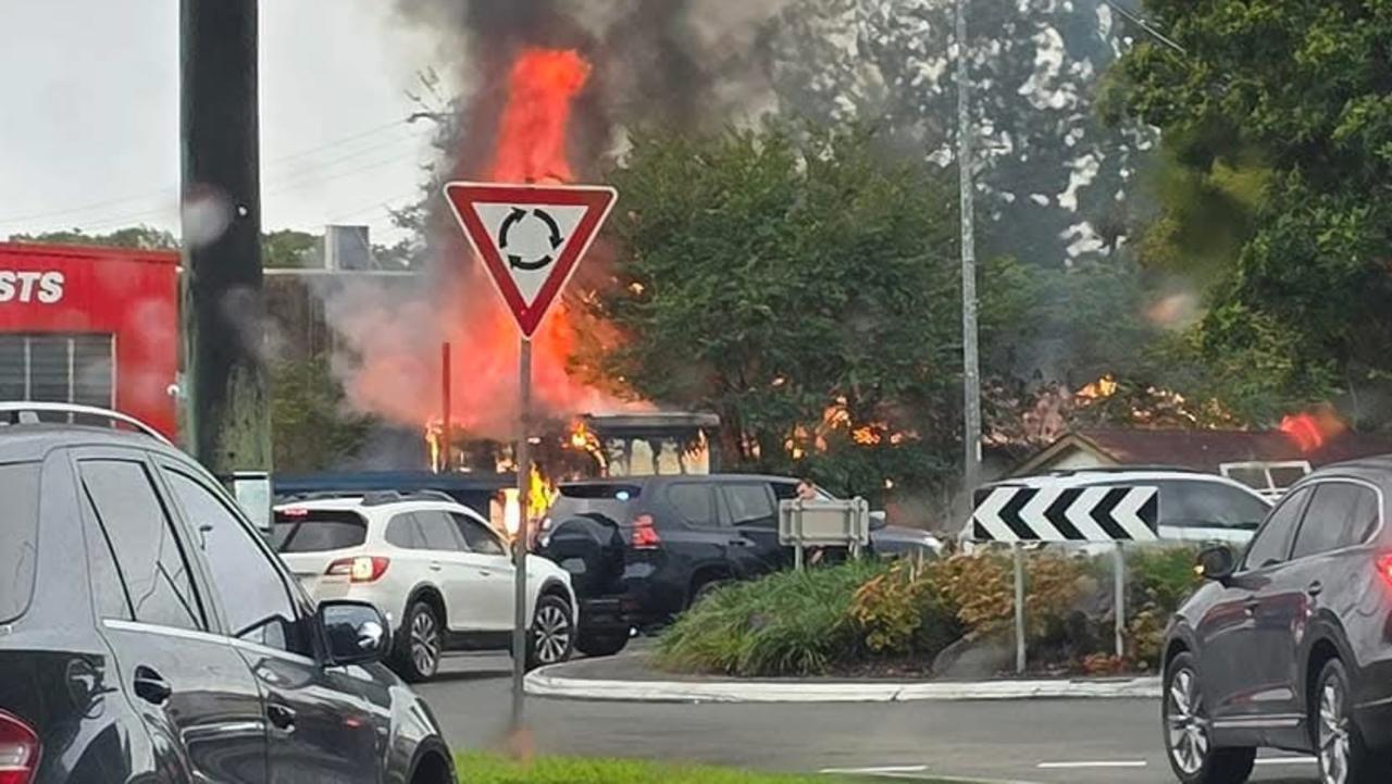 Home engulfed in flames next to busy car yard