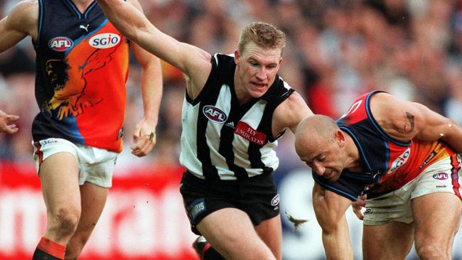 West Coast’s Peter Matera tries to pick up a loose ball under pressure from Collingwood’s Nathan Buckley during a match in 2000.