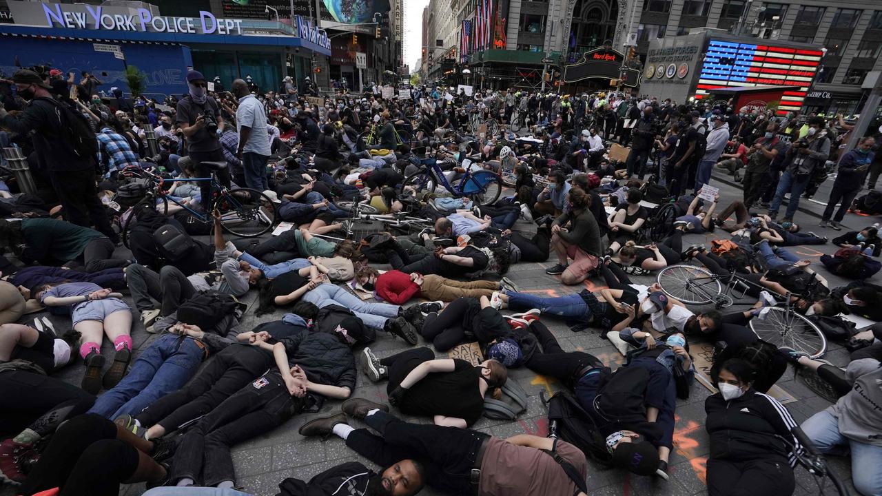 Black Lives Matter protesters lay on the ground with their hands behind their back in Times Square. A curfew from 11pm to 5am has been imposed in New York City. Picture: Timothy A Clary/AFP