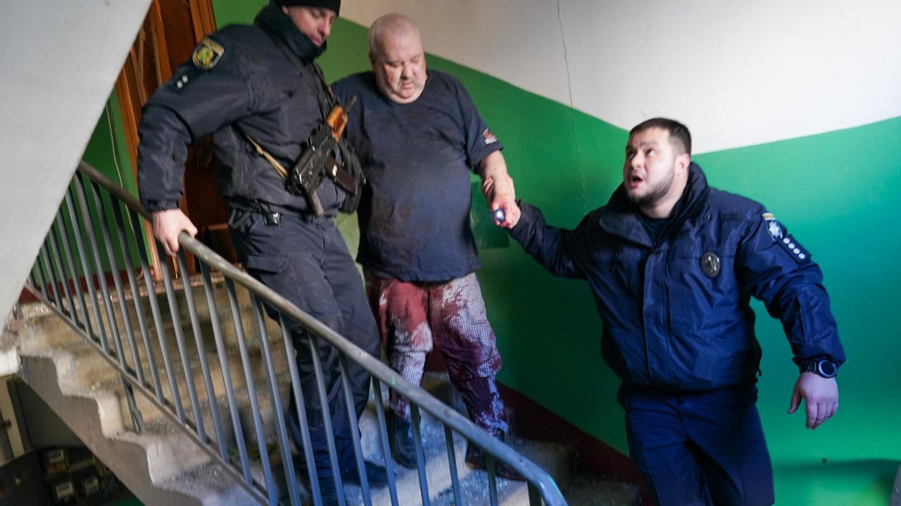 Ukrainian security forces accompany a wounded man out of the destroyed building. Picture: Wolfgang Schwan/Anadolu Agency via Getty Images