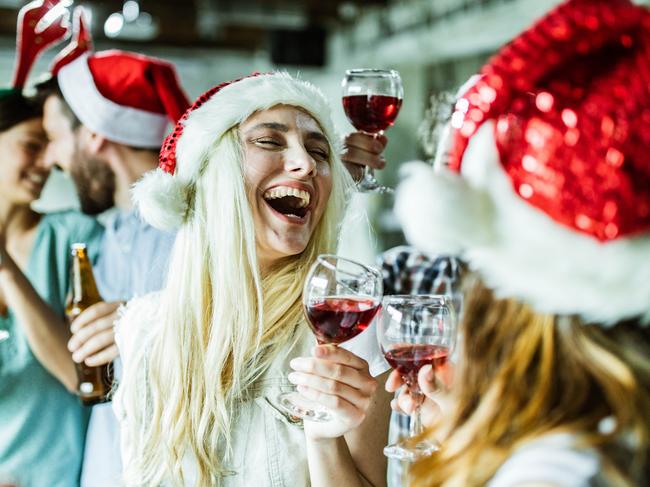 Group of cheerful creative people having fun on Christmas party in the office. Focus is on blond woman.