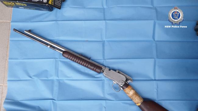 Rifle hidden in kitchen compartment, $10,000 and knuckle dusters seized in Toongabbie. Source: NSW Police