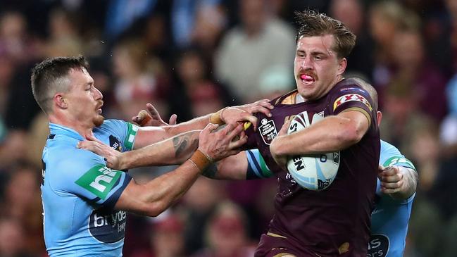 Cameron Munster fends off a Damien Cook tackle last year. Picture: Cameron Spencer/Getty Images