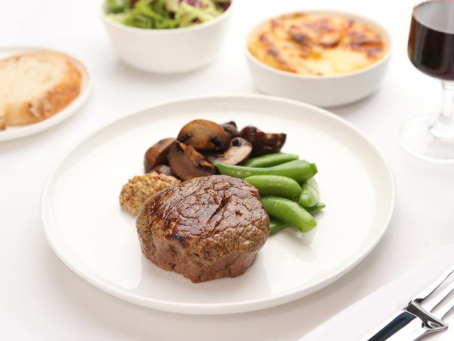 Rockpool Bar & Grill style Cape Grim beef fillet with Jerusalem artichoke gratin, garlic mushrooms, sugar snaps and horseradish relish. Now included on Qantas first-class menu on international A380 services from March 1 to May 31. Picture: Supplied