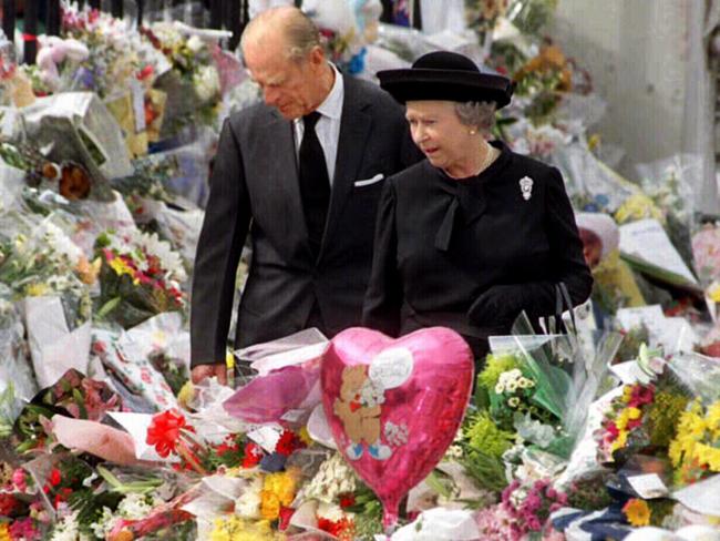 The Duke of Edinburgh, Prince Philip and Queen Elizabeth II, walking through a sea of floral tributes outside Buckingham Palace after Diana’s death. Picture: AFP