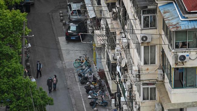 Residents walk on a street next to their neighbourhood during a Covid-19 coronavirus lockdown in the Jing'an district in Shanghai on May 17, 2022. Picture: AFP