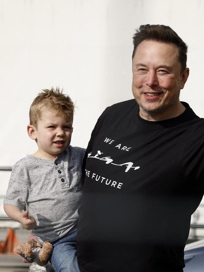 Elon Musk holds his son.