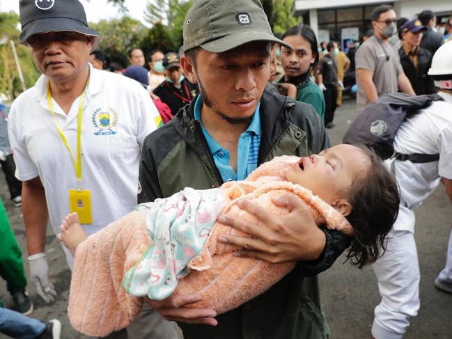 Rescuers carry a young girl after the earthquake hit Cianjur, Indonesia, 21 November 2022. Picture: EPA/ADI WEDA.