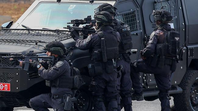 Israeli security forces take position behind an armoured vehicle at a checkpoint near Sderot.