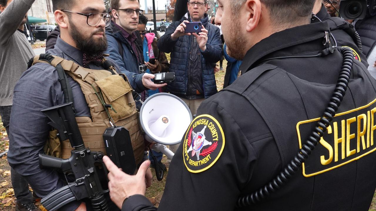 Police question a demonstrator armed with an AR-15 style weapon outside of the Kenosha County Courthouse. Picture: Scott Olson/Getty Images/AFP