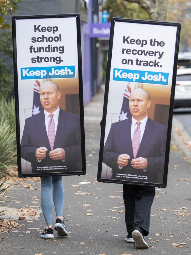 Carrying Coalition hopes on their shoulders, billboard-wearing workers trudge the streets of Hawthorn in Melbourne. Picture: Aaron Francis