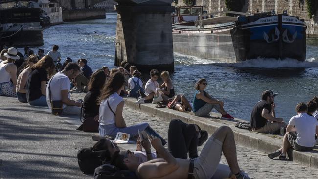 Parisians relax on the bank of the Seine. Picture: AP.