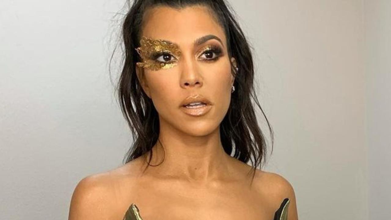 Kourtney Kardashian in a plunging gold jumpsuit.