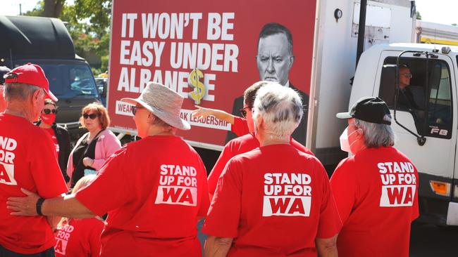 PERTH, AUSTRALIA - MAY 16:  A vehicle displaying political advertising makes it's way past Labor Party supporters at a pre-polling booth in the suburb of Wanneroo on May 16, 2022 in Perth, Australia. The Australian federal election will be held on Saturday 21 May, 2022. (Photo by Lisa Maree Williams/Getty Images)