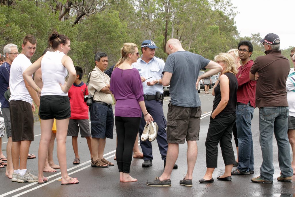 A police officer fields questions by motorists starnded on the Maryborough side of the Bruce Highway. Photo: Robyne Cuerel / Fraser Coast Chronicle. Picture: Robyne Cuerel