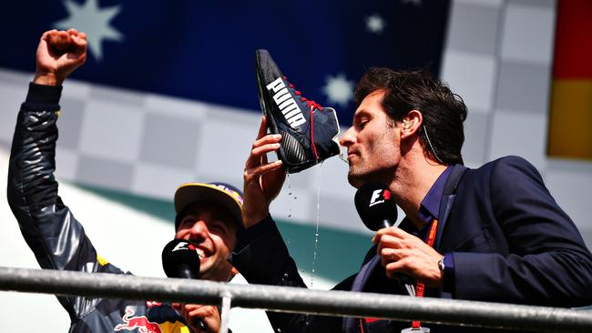 Mark Webber drinks champagne from the boot of Daniel Ricciardo.
