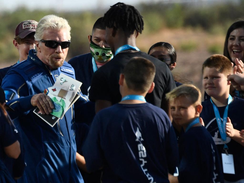 Richard Branson (L) receives some cards from children as he walks out from Spaceport America, near Truth and Consequences, New Mexico, before travel to the cosmos. Picture: AFP