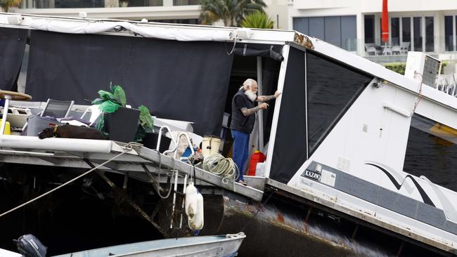 The house boat which sank in Paradise Point. Pictured is the owner on the vessel. Photo: Tertius Pickard