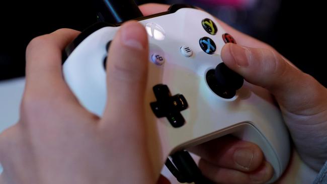 (FILES) In this file photo taken on November 5, 2017 a gamer plays video games with a Xbox console during the 2017 Paris Games Week exhibition at the Porte de Versailles exhibition centre in Paris. Video gaming can be addictive in the same way as cocaine or gambling, the World Health Organization said on June 18, 2018 in a much anticipated update of the International Classification of Diseases (ICD-11). / AFP PHOTO / Thomas SAMSON