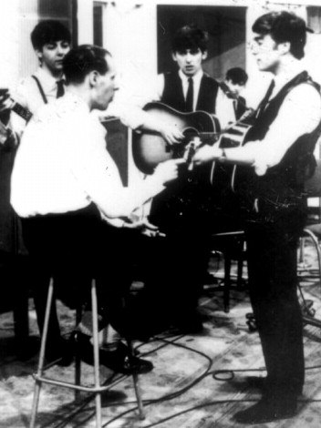 Music producer Sir George Martin (back to camera) with The Beatles in 1963. Picture: Courtesy EMI Records Australia.