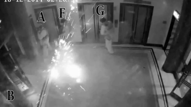 Flash bang stun grenades are thrown as police assault the building.