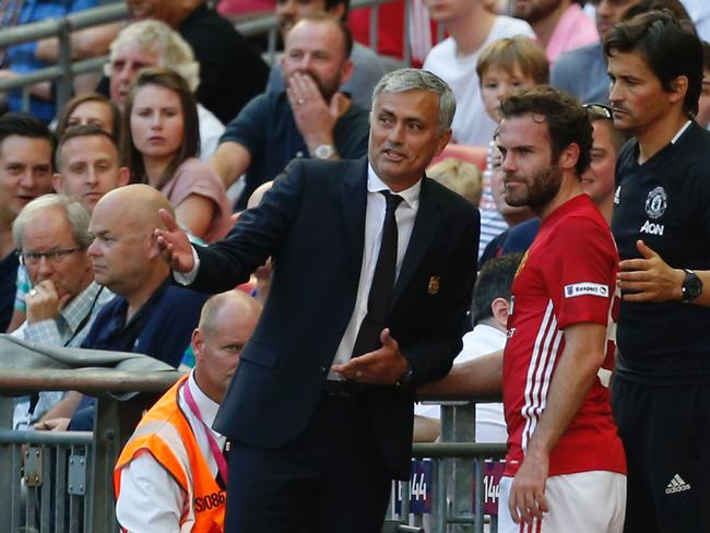 Manchester United's Spanish midfielder Juan Mata (C) talks with Jose Mourinho.