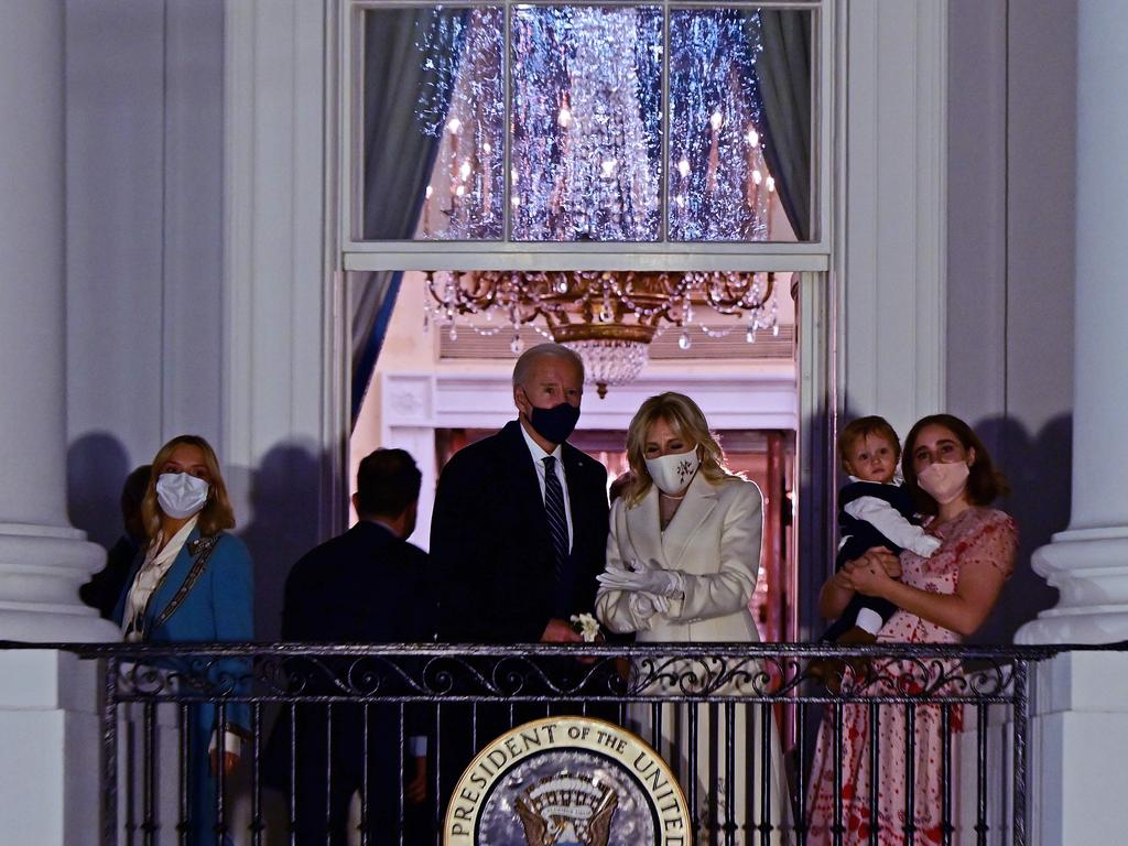 Mr and Dr Biden appear on the Blue Room Balcony with family members to watch fireworks from the White House in Washington, DC oat the end of Inauguration Day. Picture: JIM Watson / AFP