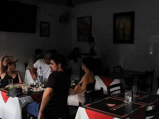 People sit inside a restaurant in Santiago, the capital of Chile, that was affected by Tuesday afternoon's nationwide power outage