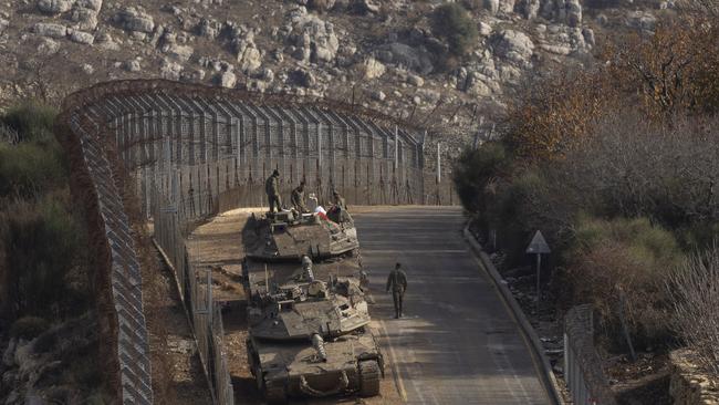 Israeli soldiers stand near tanks near the border with Syria on the Israeli side of the border on December 9, in Golan Heights. Picture: Getty