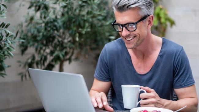 Man working on a laptop at home; Happy investor generic