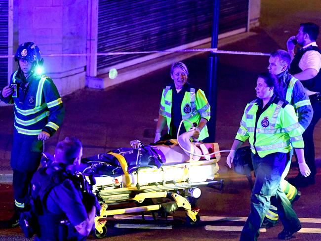 A bystander is taken away on a stretcher by distressed ambulance crews. Picture: REX/Shutterstock