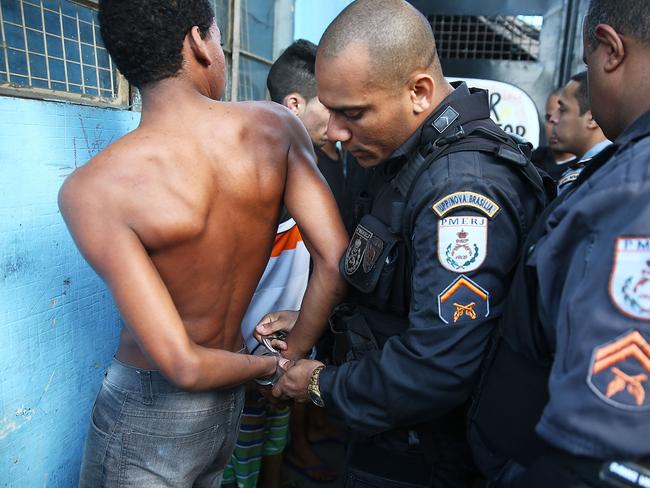 A suspect is handcuffed by military police during a joint operation including the CORE police special forces.