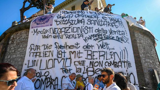 People unfold a banner written in Italian and German as protesters from "No Mask" movements, Covid deniers movements, anti-5G movements and anti-vaccination movements gather for a protest against the government's health policy on September 5 in Rome. Picture: AFP