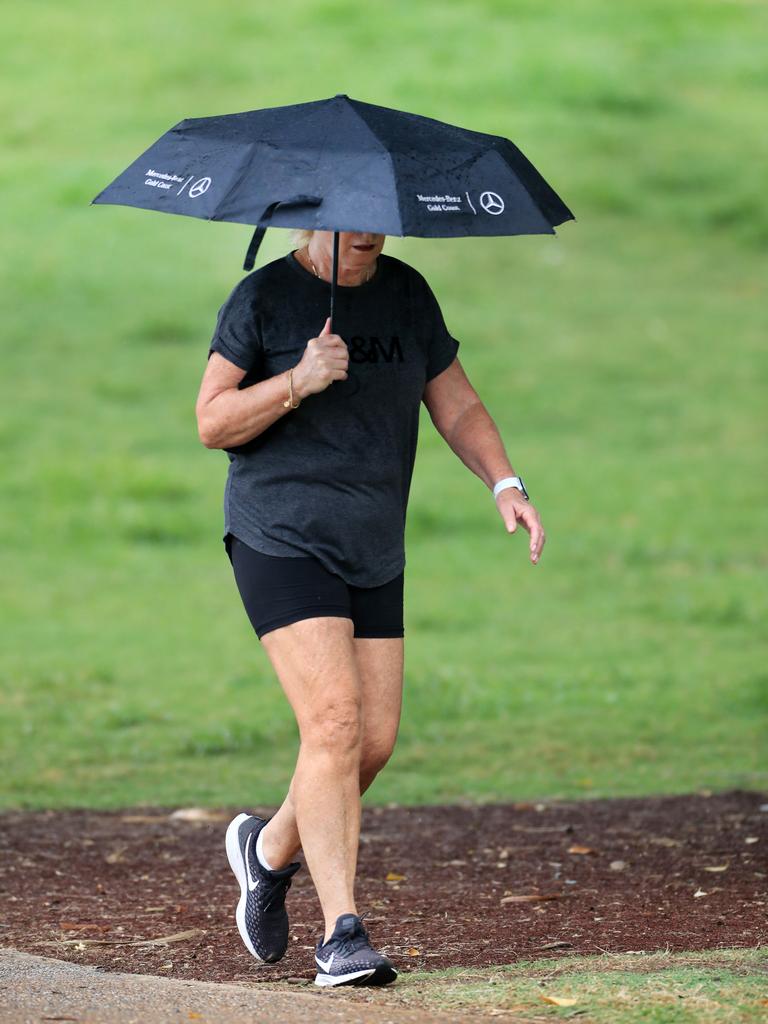 A loan walker at Burleigh Beach braves the rain as wet weather descended over the Gold Coast. Photo: Scott PowickNEWSCORP