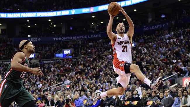 Toronto Raptors' Greivis Vasquez, right, drives for the net as Milwaukee Bucks' Jerryd Bayless looks on.