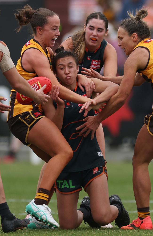 Rebecca Beeson of the Giants is tackled by two Hawks players. Picture: Daniel Pockett/Getty Images.