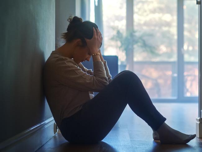 istock generic:  woman, abuse, DV, domestic violence, harassment, sexual harassment.   Sad Young Woman Sitting on the Floor In the Hallway of Her Appartment, Covering Face with Hands. Atmosphere of Depression, Trouble in Relationship, Death in the Family. Dramatic Bad News Moment . Picture: istock