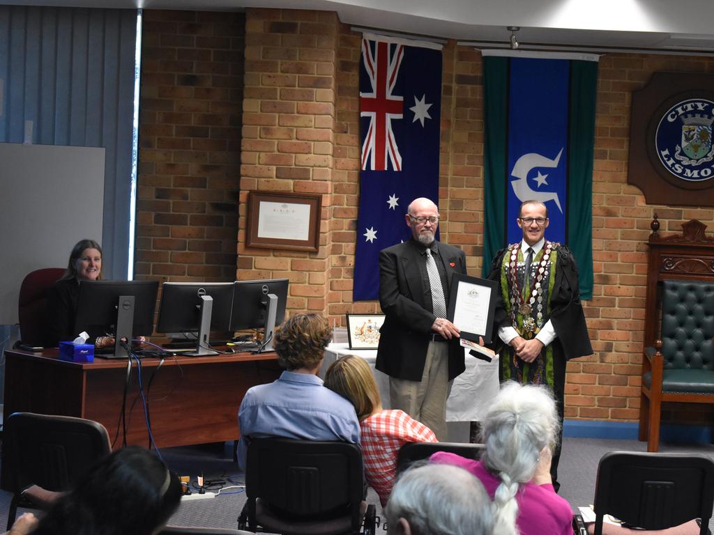 Michael Merritt receiving his citizenship from mayor Isaac Smith