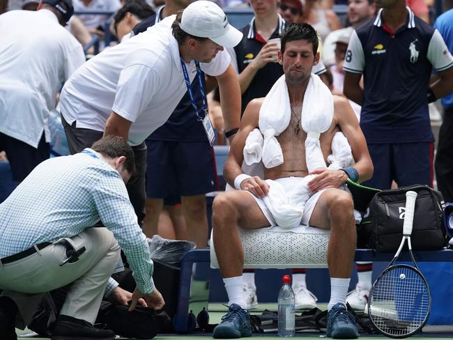 Novak Djokovic of Serbia takes a break from the heat while playing against Marton Fucsovics of Hungary. Picture: AFP