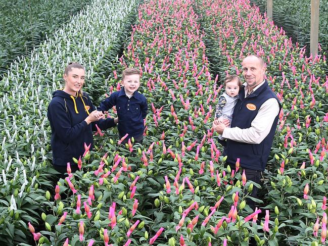 Dan Wilson, with his partner Natalie, and their kids three-year-old Ollie and five-month-old Pippa, at Sunny Hill Flowers, Silvan. Picture: Yuri Kouzmin.