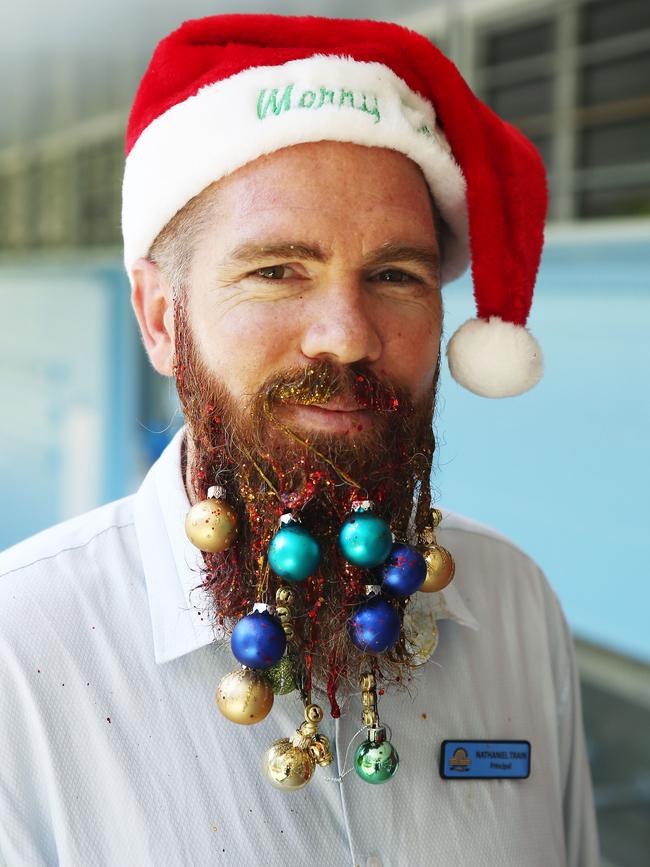 Yorkeys Knob State School principal Nathaniel Train has allowed two grade four art students to decorate his beard in festive fashion on the last day of school. Picture: BRENDAN RADKE.