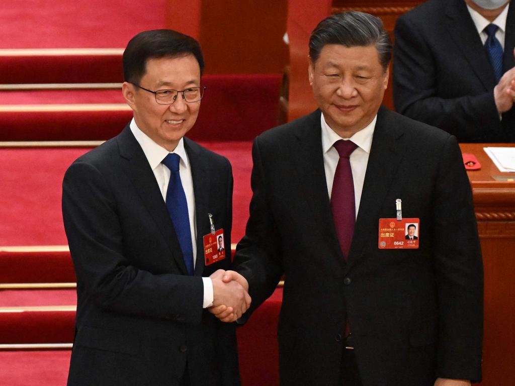 Newly-elected Vice President Han Zheng (C) shakes hands with China's President Xi Jinping (R) during the third plenary session of the National People's Congress.