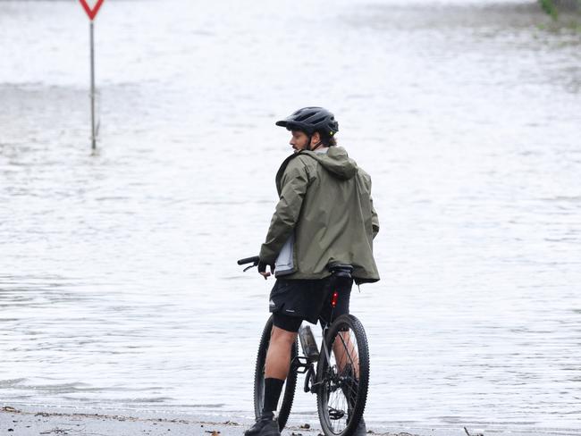 A cyclist takes in Lismore under floodwaters. Picture: Matrix/ Nathan Smith