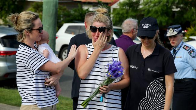 People leave flowers and toys at the Camp Hill scene on Friday. Picture AAP